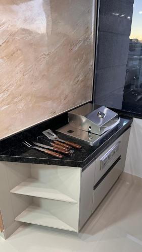 a kitchen with a counter top with a grill at O melhor Apê da Região com Ar Cond, Wi-Fi e Hidromassagem in Brasilia