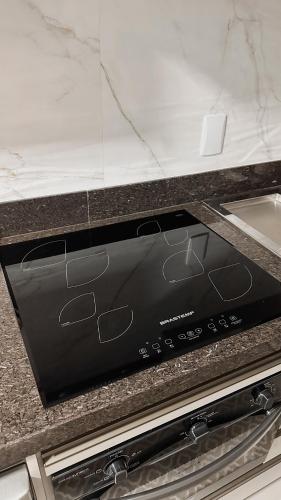 a stove top oven sitting on top of a counter at O melhor Apê da Região com Ar Cond, Wi-Fi e Hidromassagem in Brasilia