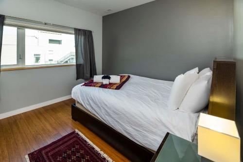 a bedroom with a bed with white sheets and a window at NN - The Kit 4 - Downtown 1-Bed 1-Bath in Whitehorse