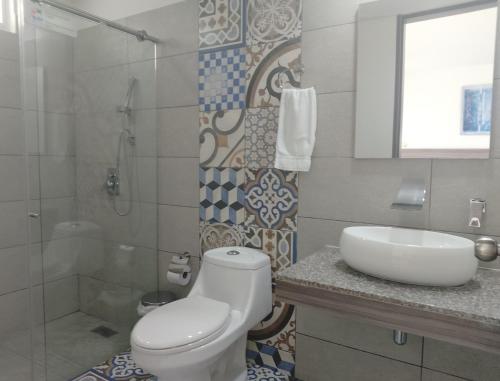 a bathroom with a toilet and a sink and a shower at HOTEl PALO GRANDE CF PEREIRA in Pereira