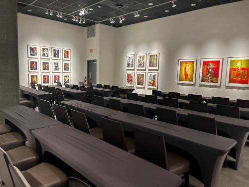 a room with chairs and paintings on the walls at Kimpton Rowan Palm Springs Hotel by IHG in Palm Springs