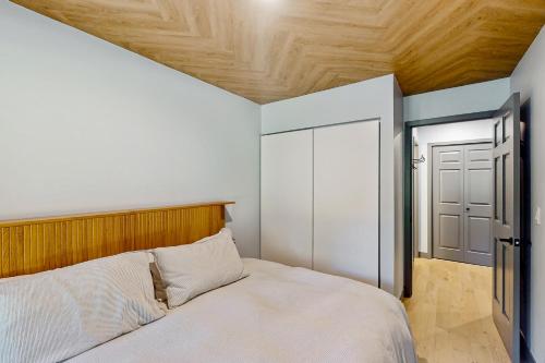 a bedroom with a bed with a wooden headboard and a door at Spruce Creekside in Vail