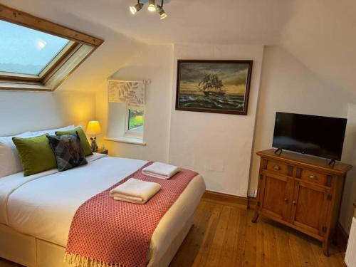 a bedroom with a bed and a flat screen tv at The Snug at Cherry Cottage by MaisonPro in Matson
