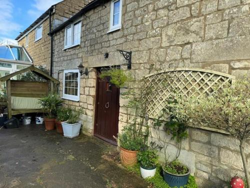a brick house with plants in front of it at The Snug at Cherry Cottage by MaisonPro in Matson