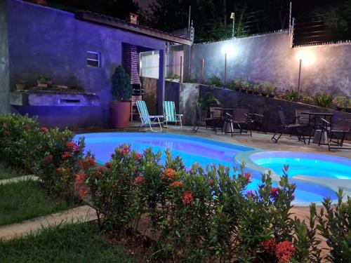 a swimming pool in a backyard at night at Casa Natureza in Camaçari