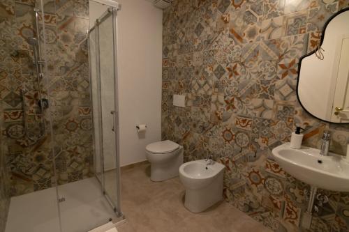 ein Badezimmer mit Toilette, Waschbecken und Dusche in der Unterkunft R-Home Exclusive Rooms in Catania