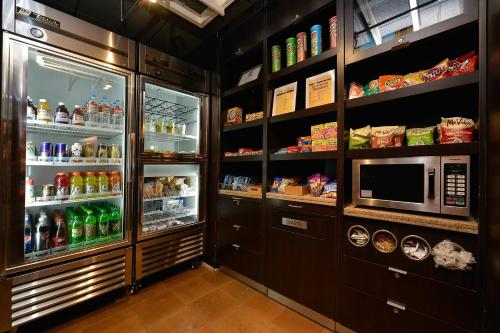 a kitchen with a refrigerator and a microwave at Courtyard by Marriott Bentonville in Bentonville