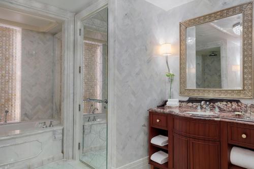 a bathroom with a shower and a tub and a sink at The St. Regis Abu Dhabi in Abu Dhabi