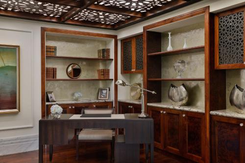 a room with a desk and shelves with vases at The St. Regis Abu Dhabi in Abu Dhabi