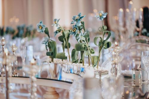 a table with a bunch of vases with blue flowers at The St. Regis Abu Dhabi in Abu Dhabi