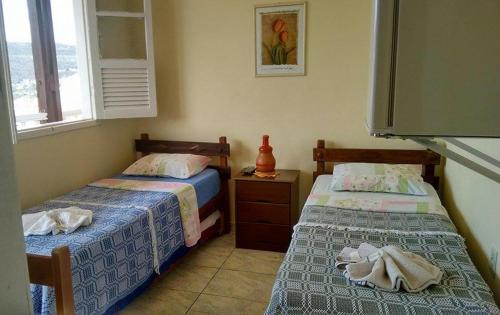 een slaapkamer met 2 bedden en een raam bij Pousada Presidente in Diamantina