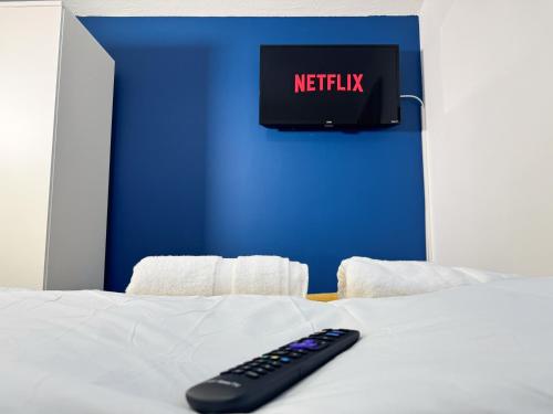 a remote control sitting on top of a bed at Wellesley Retreat 4BR Entire Home in Middlesbrough