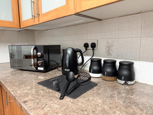 a kitchen counter with a coffee maker and a microwave at Wellesley Retreat 4BR Entire Home in Middlesbrough