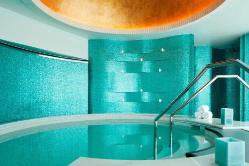 a bathroom with a tub with blue walls at The St. Regis Abu Dhabi in Abu Dhabi