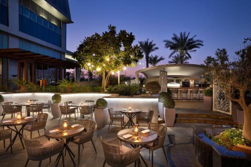 an outdoor patio with tables and chairs and a building at The St. Regis Abu Dhabi in Abu Dhabi