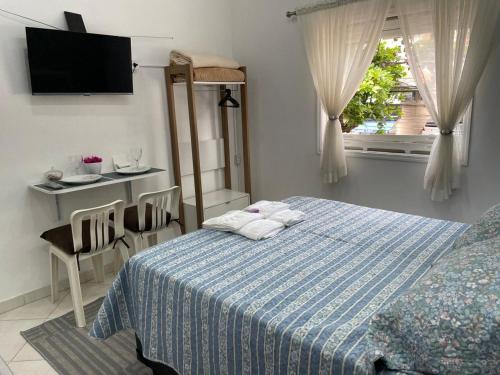 a bedroom with a bed and a table and a window at Apartamento Cidade de Deus in Osasco