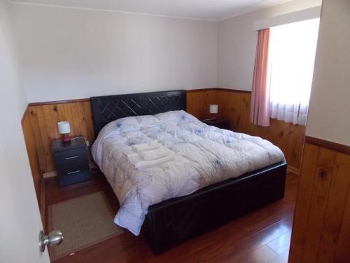 a bedroom with a bed with white sheets and a window at Cabañas Inadeqin in Ensenada