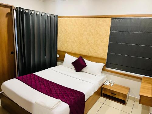 a small bedroom with a bed and a window at Focuz Habitat Hotel And Ayurveda in Malappuram