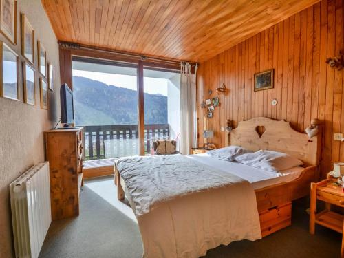 une chambre avec un lit et une grande fenêtre dans l'établissement Appartement cosy à Morzine - 2 pièces, piscine, balcon, parking - 4 pers - FR-1-684-50, à Morzine