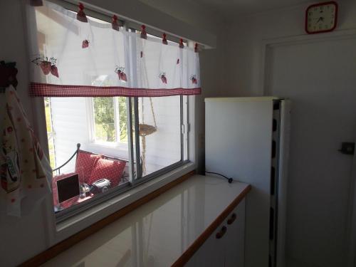 a kitchen with a window and a refrigerator at Cabañas Inadeqin in Ensenada