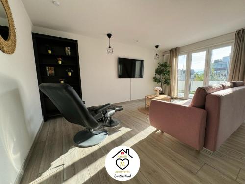 a living room with a chair and a couch at Family M Apartments 21-22 in Sempach