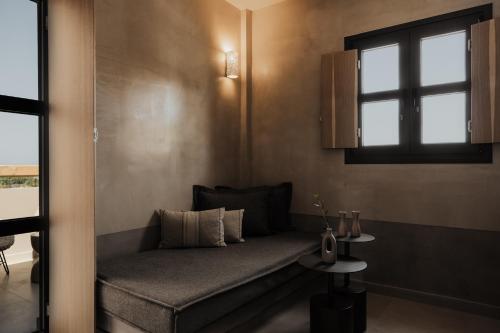 a couch sitting in a room with a window at Momi Slow Living Hotel in Hersonissos