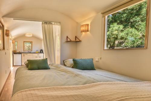 a bedroom with a large bed with two green pillows at Casa el Refugio Stilte Comfort Natuur Uniek in Canillas de Aceituno