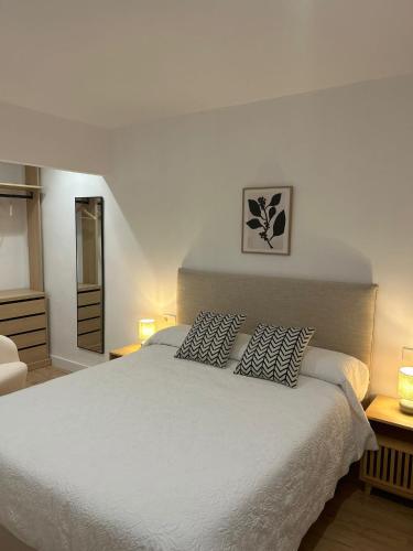 a bedroom with a large white bed with two pillows at Loft Atemporal, centro de Ciudad Real in Ciudad Real