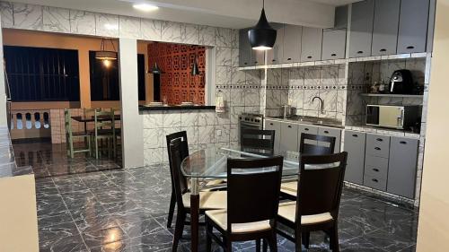 a kitchen with a glass table and chairs at Casa Naza in Areia