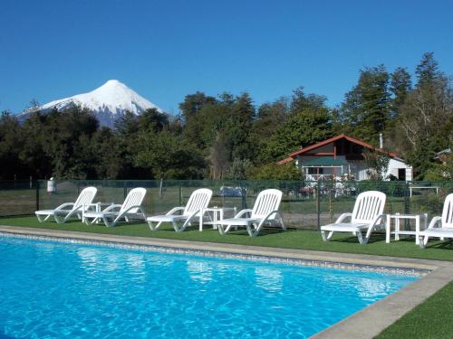 a group of white chairs sitting next to a pool at Cabañas Inadeqin in Ensenada