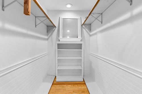 an empty hallway with white walls and white stairs at Canandaigua Lake Retreat with view and private beach access, foliage, hike, and Ski in Canandaigua