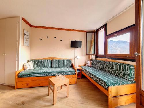 une chambre avec deux lits et une table dans l'établissement Appartement cosy 2 pièces - Proche pistes et commerces - Balcon Sud/Est - Parking gratuit - FR-1-344-973, aux Menuires