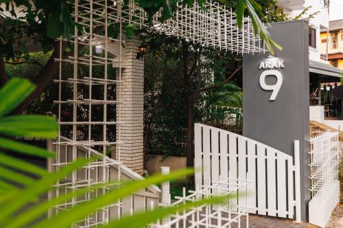 a white fence next to a building with the number at Arak 9 Villa in the Old Town in Chiang Mai