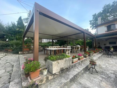 a pavilion with potted plants and a table and chairs at Azienda agrituristica Di Fiore in Morcone