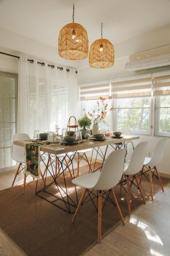 a dining room with a table and white chairs at Arak 9 Villa in the Old Town in Chiang Mai