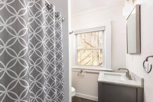 a bathroom with a toilet and a sink and a window at 2-Unit House, big Lake Winnisquam views - Sleeps 13 in Tilton