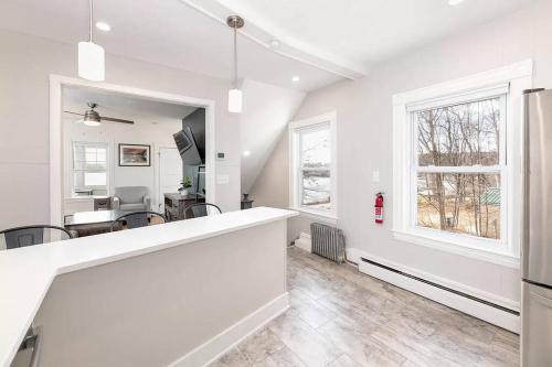 a kitchen and dining room with white walls and windows at 2-Unit House, big Lake Winnisquam views - Sleeps 13 in Tilton