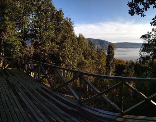 a hammock on a wooden deck with a view of a lake at Cabaña con vista al Lago Colico in Puerto Corrales