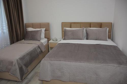 a bedroom with two beds and a window at Guest House Nuhellari in Çorovodë