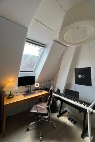 an attic office with a desk and a keyboard at K L O S T E R E T - The Luxurious Townhouse of Copenhagen in Copenhagen