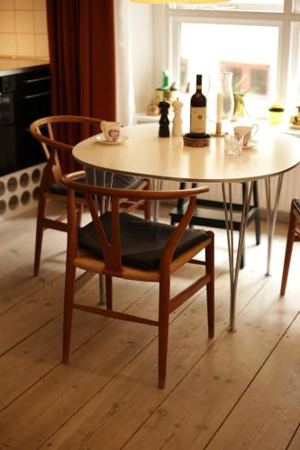 a dining room table with a chair and a table and a table at K L O S T E R E T - The Luxurious Townhouse of Copenhagen in Copenhagen