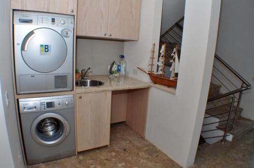 a kitchen with a washing machine and a sink at Beach Villa Pantheon in Pomos