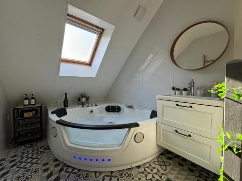 GambaisにあるLE NID - Charmante petite maison avec balnéoのバスルーム(バスタブ、鏡付)