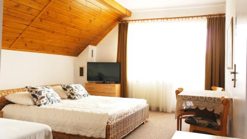 a bedroom with a bed and a tv and a couch at Anka in Władysławowo