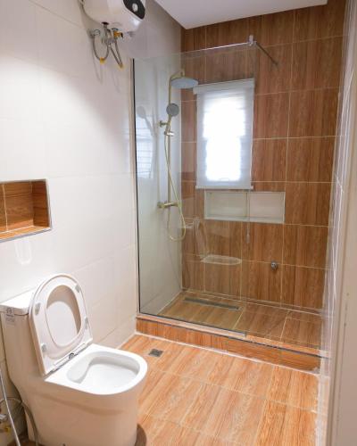 a bathroom with a toilet and a glass shower at J&O Luxury Apartment in Jahi