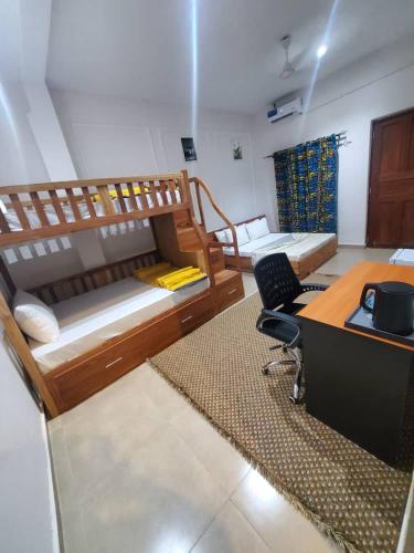 a room with two bunk beds and a desk at Sand and Sunset in Kendwa