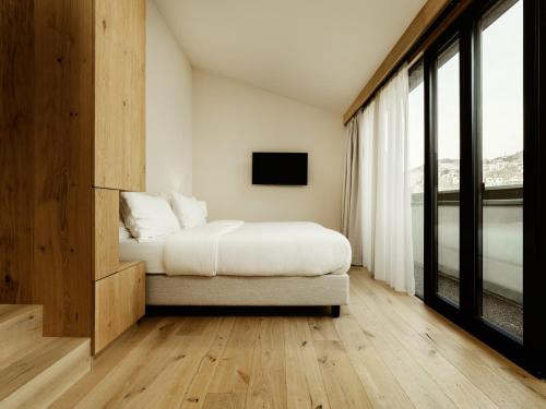a bedroom with a bed and a tv on a wall at ADLER Historic Guesthouse in Bressanone