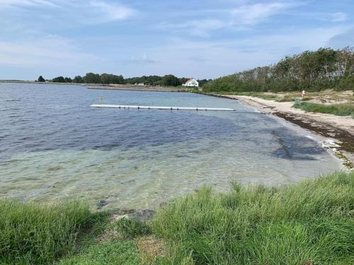 a beach with a pier in the water at Enjoy nature in silence in Ljungen