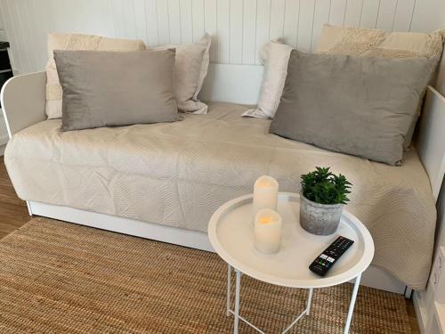 a living room with a couch and a table with two candles at Enjoy nature in silence in Ljungen