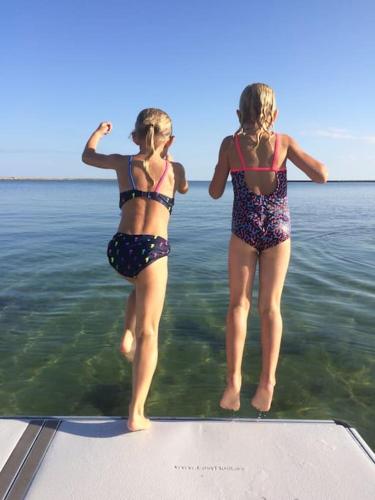 two girls standing on the back of a boat in the water at Enjoy nature in silence in Ljungen
